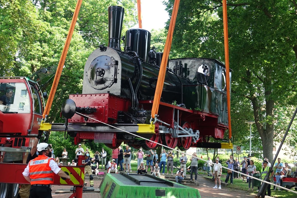 Ein Kran hievt die Dampflokomotive der früheren Kleinbahn durch das Teufelsmoor auf ihren Denkmal-Sockel.