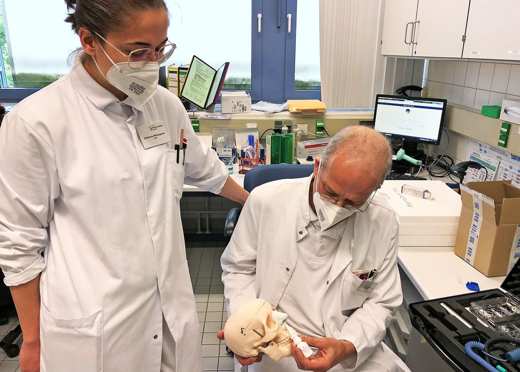 Gulnara Mirzayeva und Professor Georg Daeschlein überprüfen die Physik des potenziellen Corona-Nasensprays anhand eines Schädelmodells.