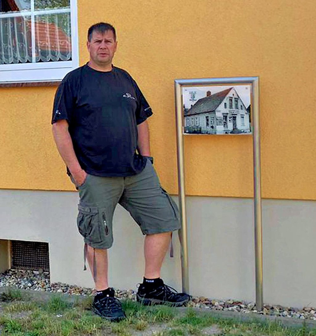 Torsten Thiel in Bittkau vor seinem Haus mit der historischen Ansicht des Gebäudes.