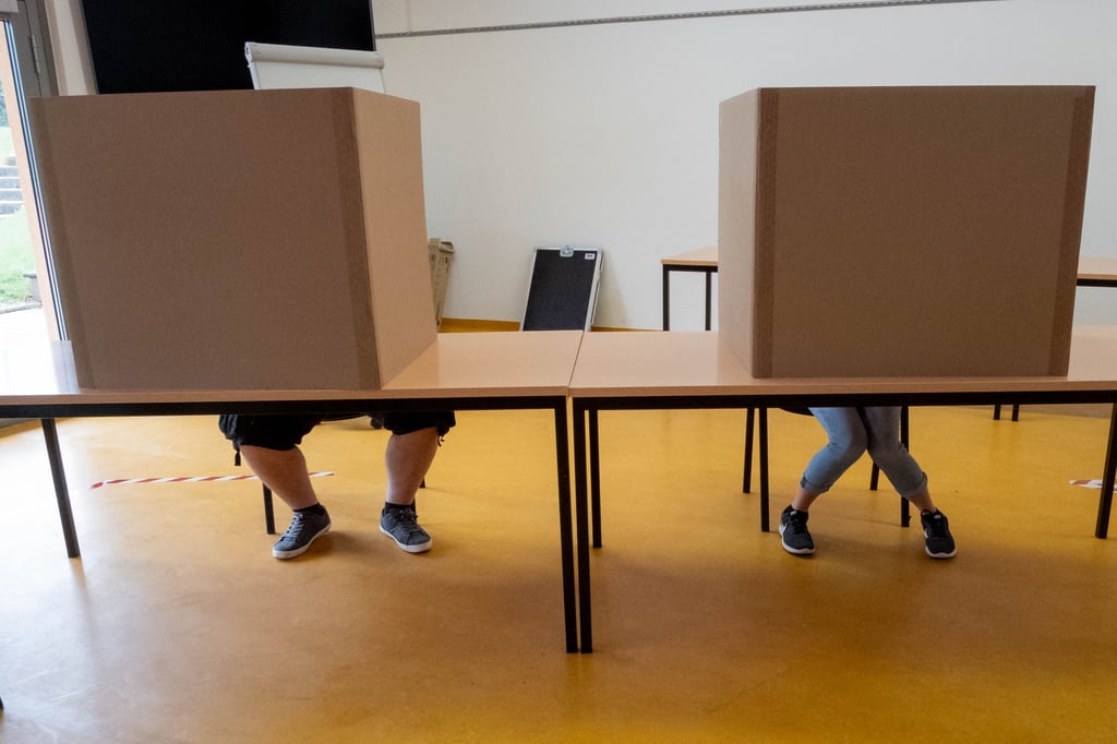 Zwei Wähler in Wahlkabinen