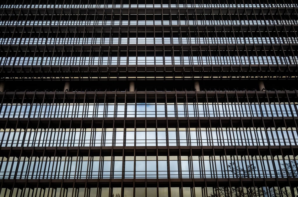 Der Himmel spiegelt sich auf der Fassade aus Glas und Stahl des Deutschen Patentamts in München.