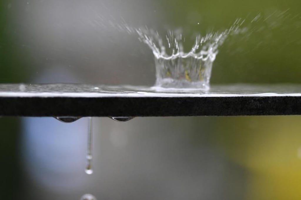 Wasser spritzt bei einem Schauer in die Höhe.