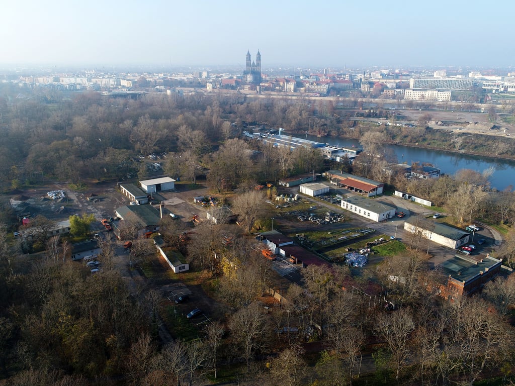Rechts der Winterhafen, daneben der alte Bauhof des Magdeburger Tiefbauamtes. Auf den grün überwucherten Brachen im Hinterland wollen Investoren eine betreute Wohnanlage für Angehörige mit Demenzkranken, kombiniert mit Kita, Restaurant und weiteren Funktionsgebäuden, errichten.