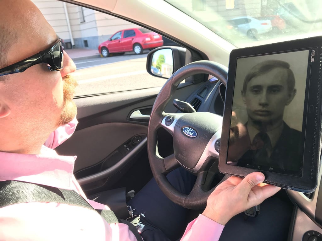 Stadtführer Juri Netschajew zeigt bei der Stadtrundfahrt "Putin in Peterburg" auch Fotos aus den frühen Jahren von Wladimir Putin.