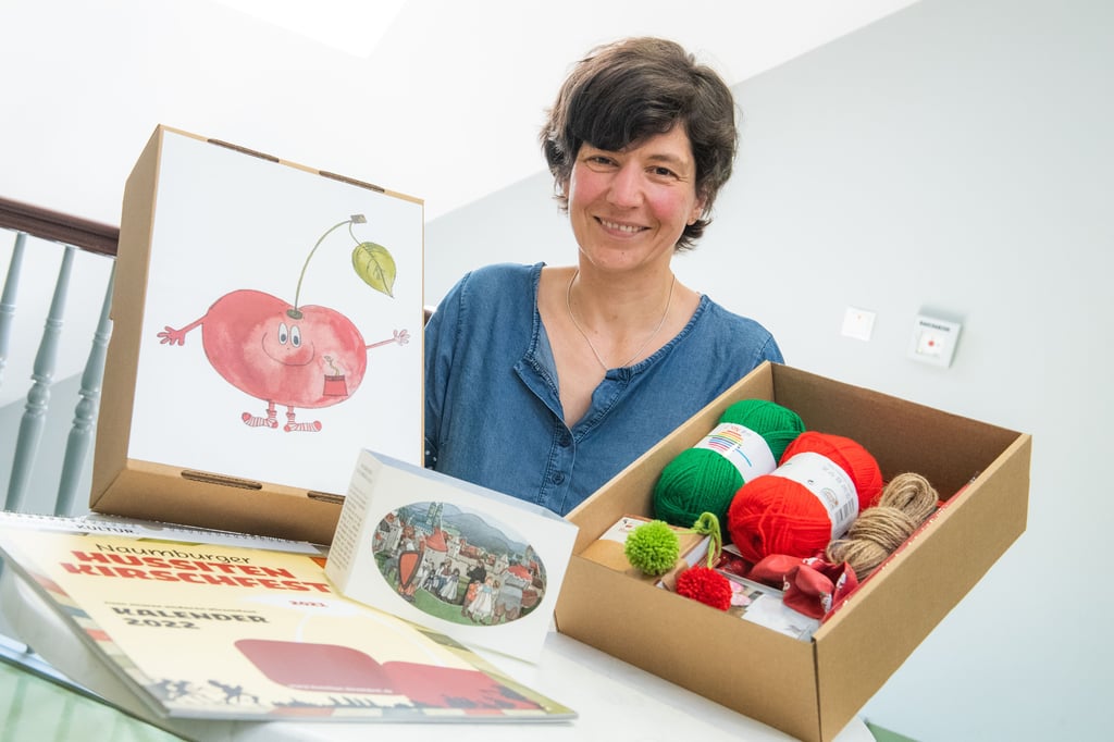 Yvonne Roth von Kultur und Tourismus Naumburg präsentiert ein Kinder-Kirschfest-Bastelpaket für Kitas und den Kirschfest-Kalender 2022.