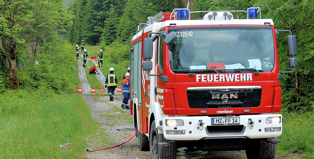 Hinter den Tanklöschfahrzeugen wurden im Wald mit viel Personaleinsatz die Löschstrecken aufgebaut. Jeder Handgriff muss im Ernstfall sitzen.