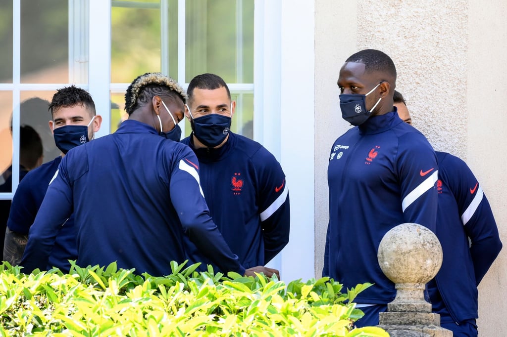 Paul Pogba (2.v.l), Karim Benzema (M) und Steve Mandanda (r) warten im Trainingslager auf die Ankunft des französischen Präsidenten Macron.