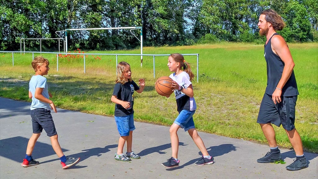 Stefan Arndt (von rechts) spielt mit seinen Kindern Martha, Erik und Willi. eine Runde Basketball am Schleibnitzer Sportplatz.