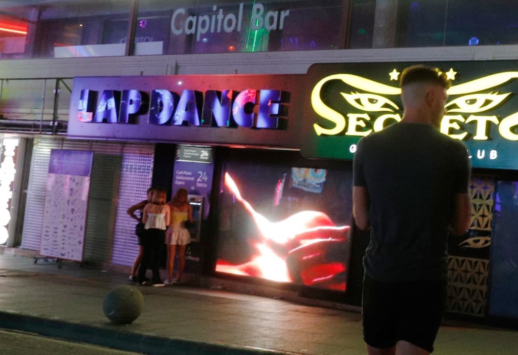 Jugendliche stehen vor einer Bar auf der Straße. Auf der Party-Insel Mallorca wird das Leben immer normaler