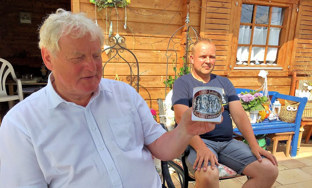 Roland Halang (li.) und Peter Heine präsentieren eine Tasse, die es im Jubiläumsjahr als Gastgeschenk geben soll.