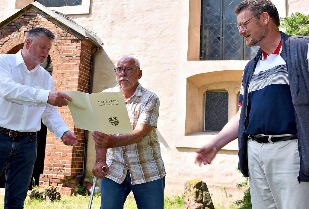 Pfarrer Dankmar Pahlings (re.) und Gemeindekirchenrat Erich Taday (Mitte) freuen sich über die Unterstützung des Landkreises. Die Fenster der Nordseite der Kirche in Osternienburg sollen saniert werden. Landrat Uwe Schulze hat sich vergangene Woche ein Bild davon gemacht.