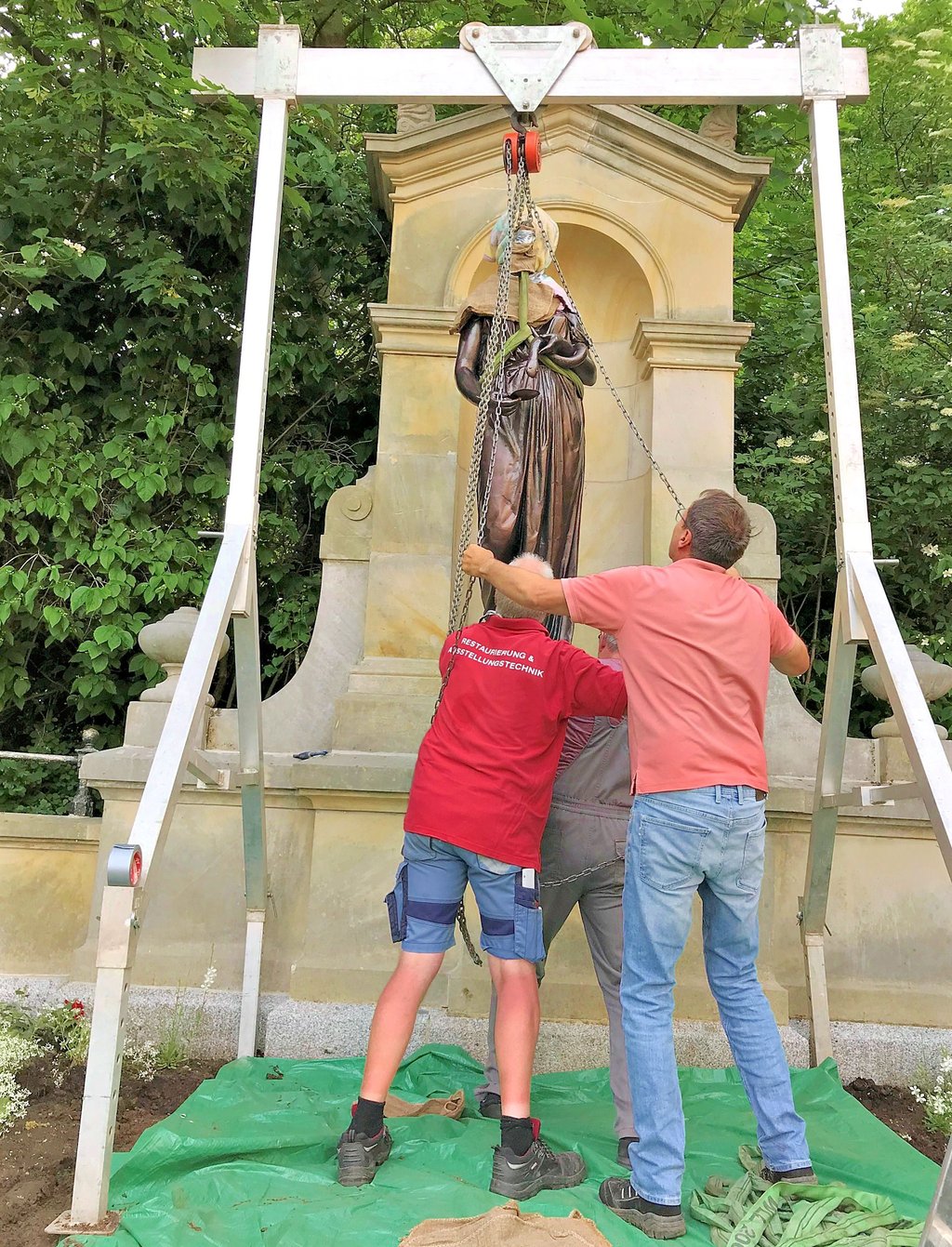 Mit einem Flaschenzug an einem Portalkran wird die Hygieia nach oben gezogen. Vorsichtig schiebt Ulrich Weidauer (li.) mit Frank Rabe (re.) und Uwe Nitschke die Figur zum Sockel.