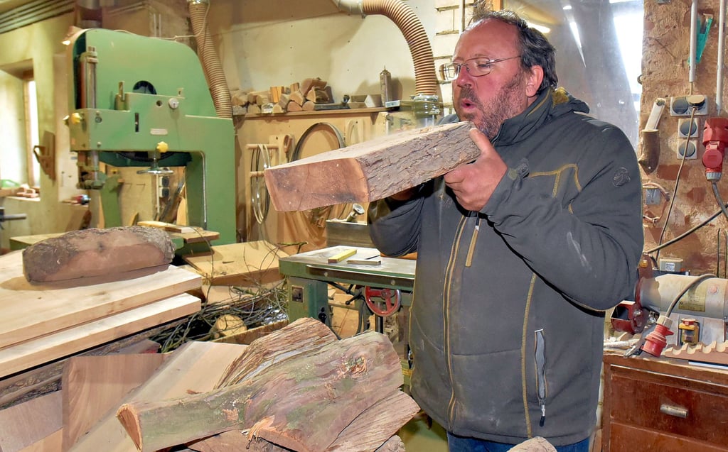 Robby Winkler bläst den Staub weg, der sich in der langen Corona-Zeit auf dem Holz abgelagert hat.