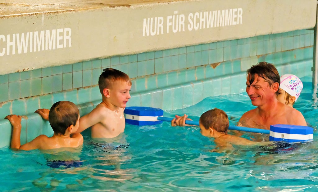 Sven Thomas von der Wasserwacht übt mit den Kindern im Stadtbad in Halle das Tauchen.
