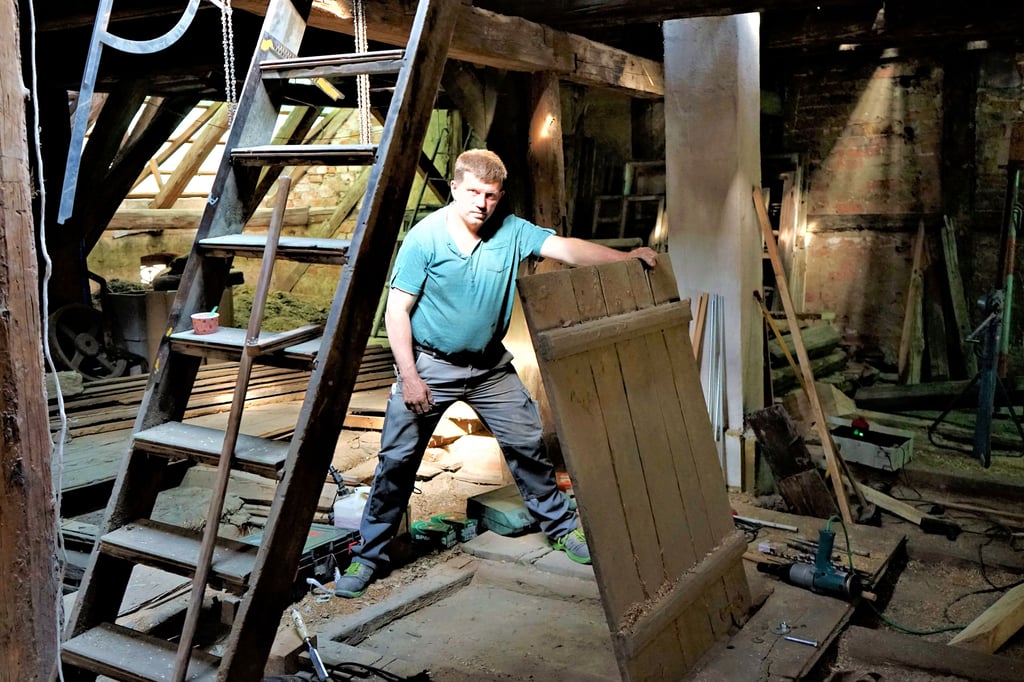 Enrico Dannies (47) auf dem Dachboden der Altperverstraße 28: Bei den Sanierungsarbeiten ist eine Falltür zum Vorschein gekommen.