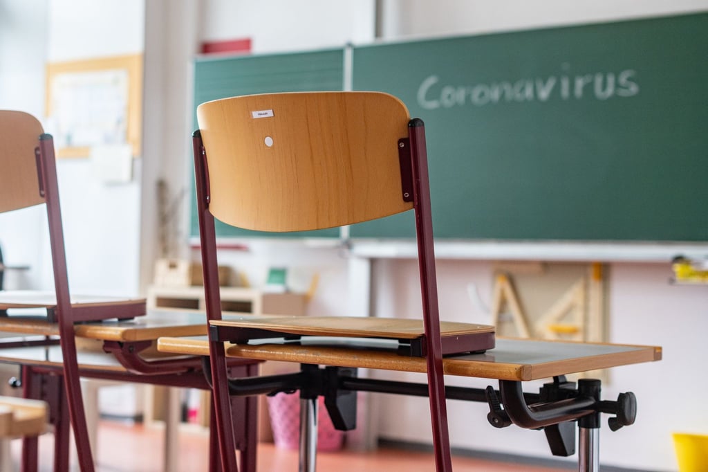 „Coronavirus“ steht auf einer Tafel in einem leeren Klassenzimmer.