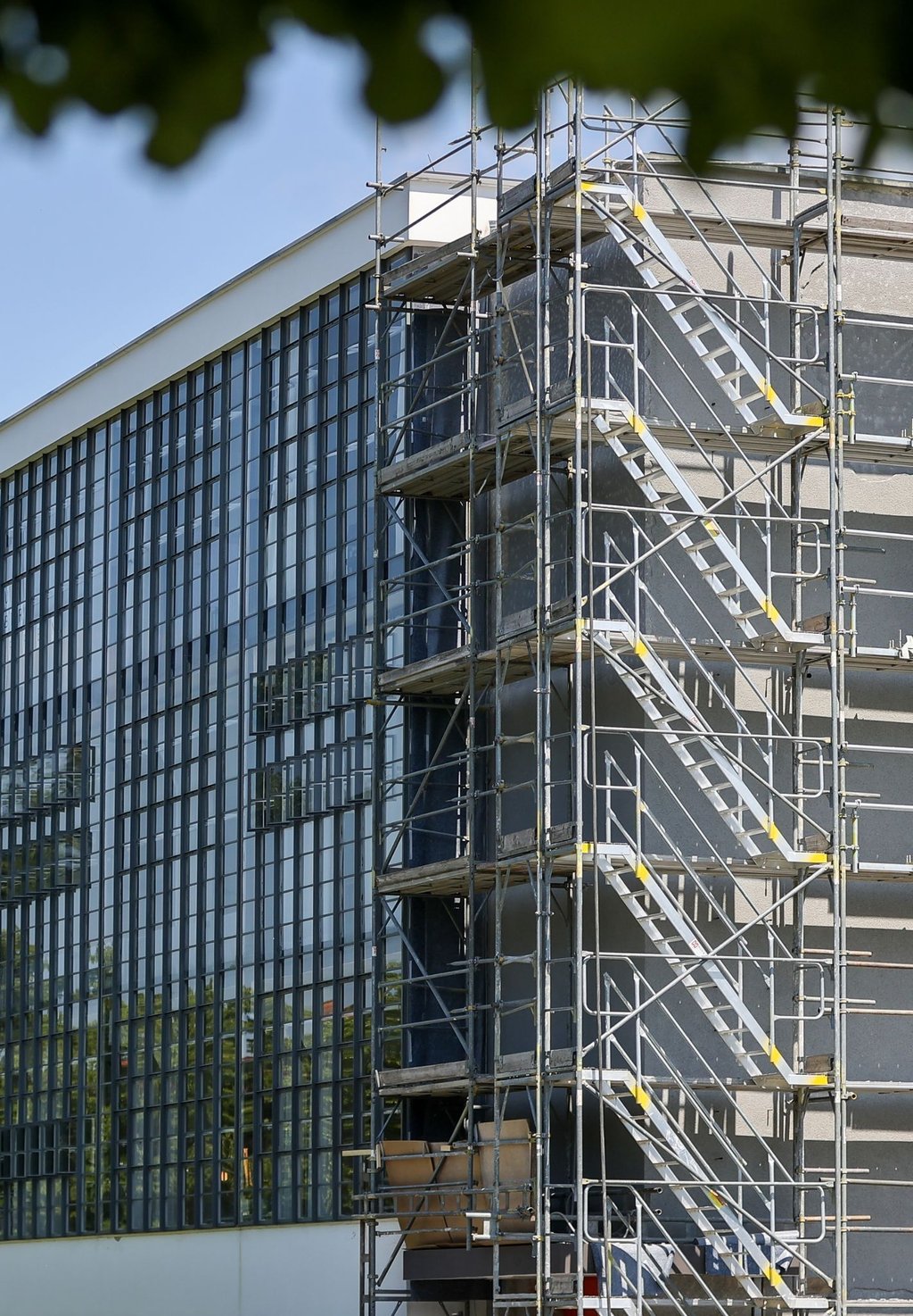 Eingerüstet und ohne den berühmten vertikalen Schriftzug steht das Bauhausgebäude in Dessau.