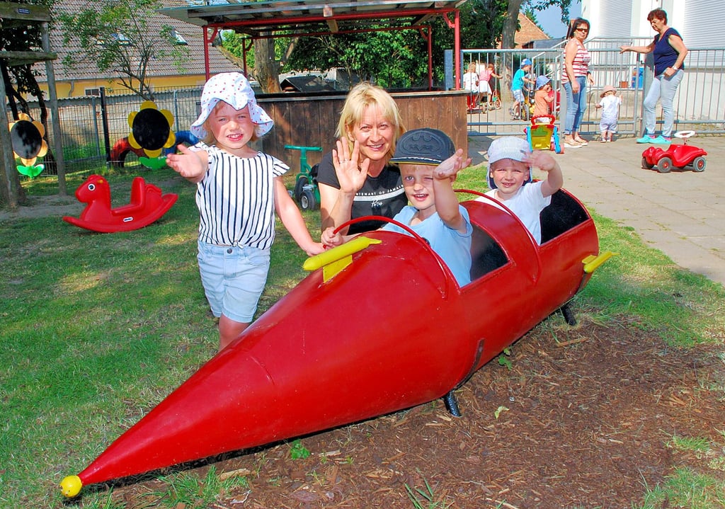 Lilly (von links), Valentin und Luke genießen in der Kindertagesstätte in Hohendodeleben den Sonnenschein mit Leiterin Diana Schiffner.