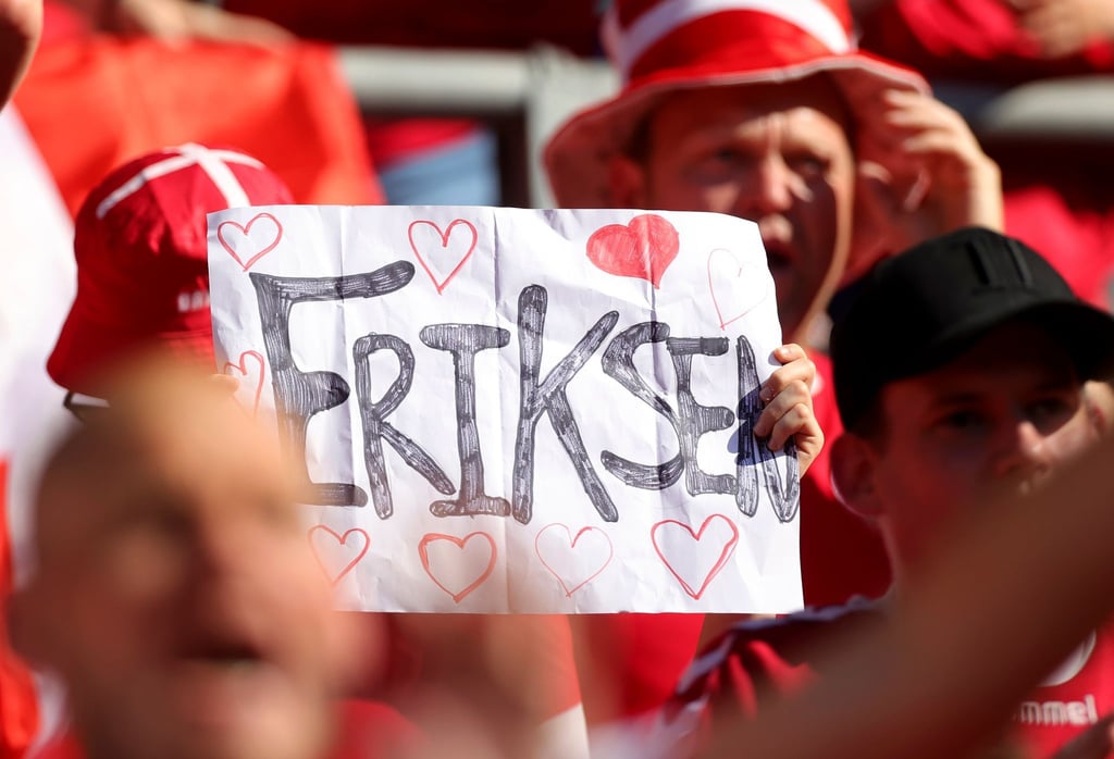 Ein dänischer Fan hebt ein Plakat für den dänischen Spieler Eriksen.