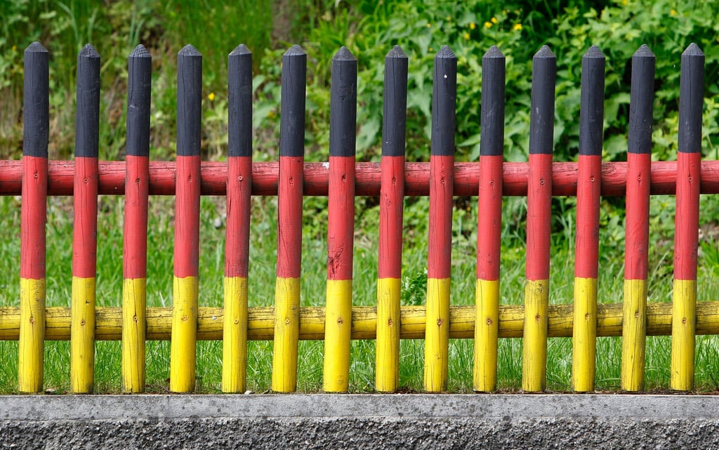 Ein in den Farben der Deutschlandfahne angestrichener Gartenzaun. Einer Studie zufolge haben sich in Deutschland zwei verfestigte Lager mit extrem gegensätzlichen Haltungen gebildet.