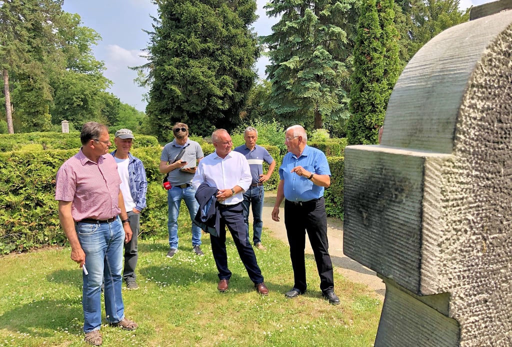 Friedhofsleiter Ronald Wenzel (l.) sowie Hartmut Klein (2.v.l) und Rolf Bielau (r.) von der IG Saatguttradition mit Oberbürgermeister Frank Ruch (3.v.r.) im Gespräch am Grabdenkmal von Julius Ebert, dessen Vorfahren mit der Tomatenzucht begannen.
