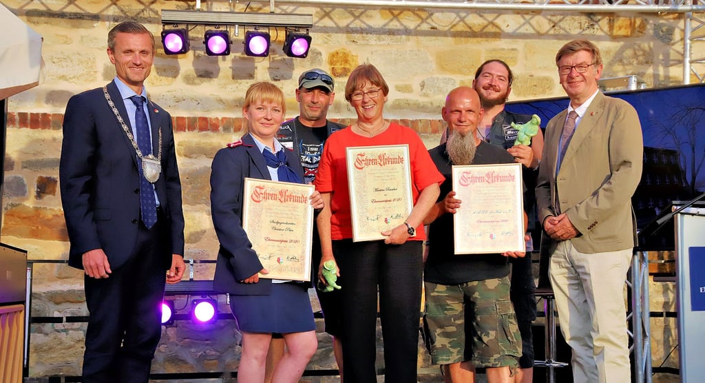 Bürgermeister Benjamin Kanngießer (links), der Stadtratsvorsitzende Wolfgang Nehring (rechts) und die Preisträger. Christine Peter ist die Zweite von links. Neben ihr ist Martina Reuscher zu sehen. Die Herren in schwarz gehören zu „M.A.DE. For Kids“.