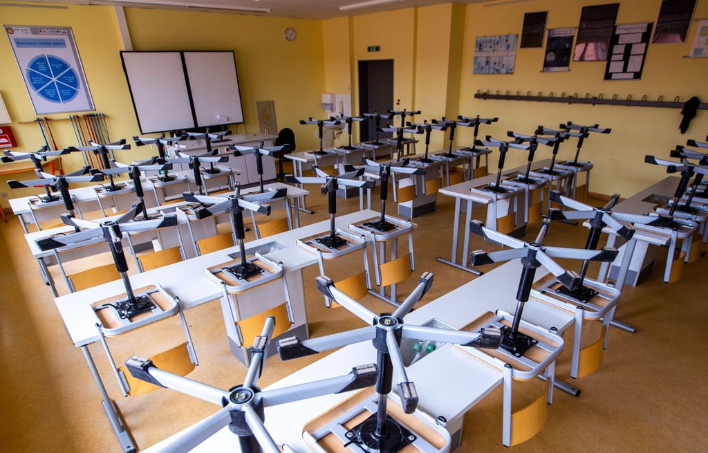 Die Stühle in einem Klassenzimmer eines Gymnasiums sind hochgestellt.