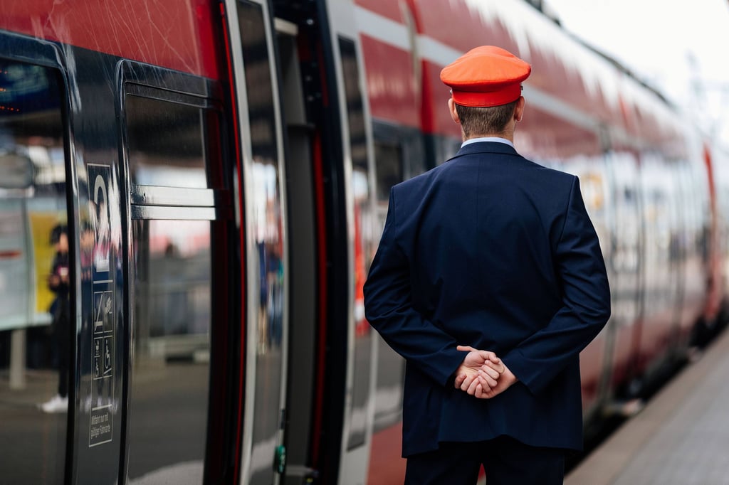 Ein Zugbegleiter an einer Regionalbahn.