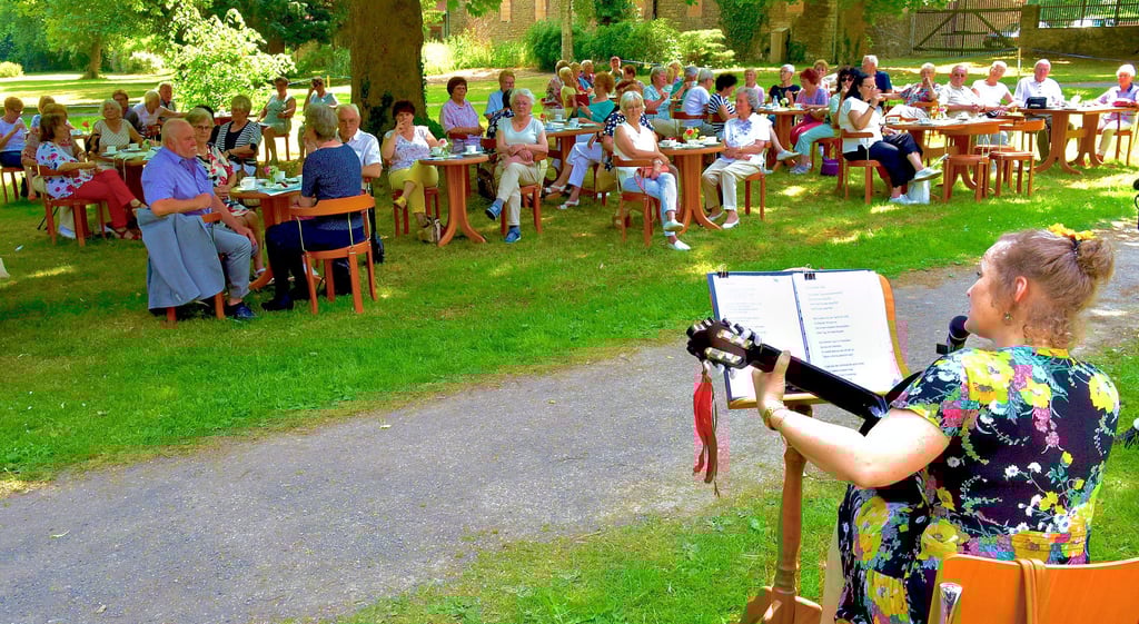 Die ausgebildete Opernsängerin Aline Berlitz (re.) spielte für die rund 90 Gäste des Rosenfestes im Schlosspark in Oberwiederstedt.