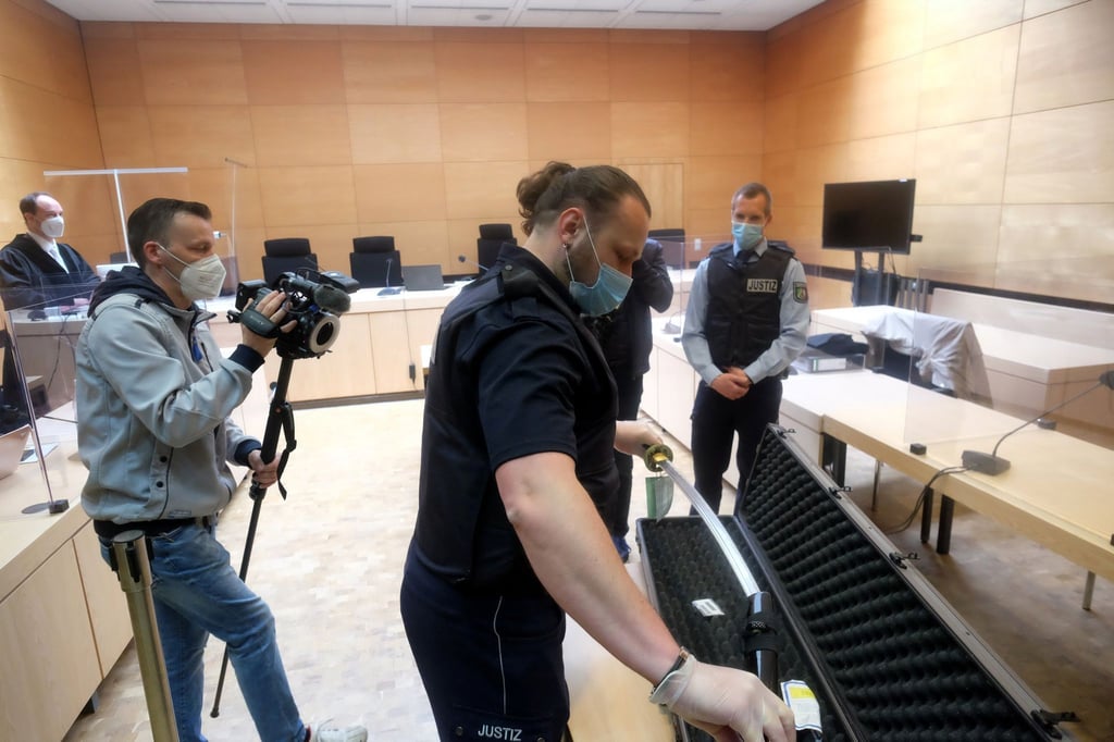 Ein Justizbeamter zeigt im Bielefelder Landgericht am ersten Prozesstag das Samurai-Schwert.