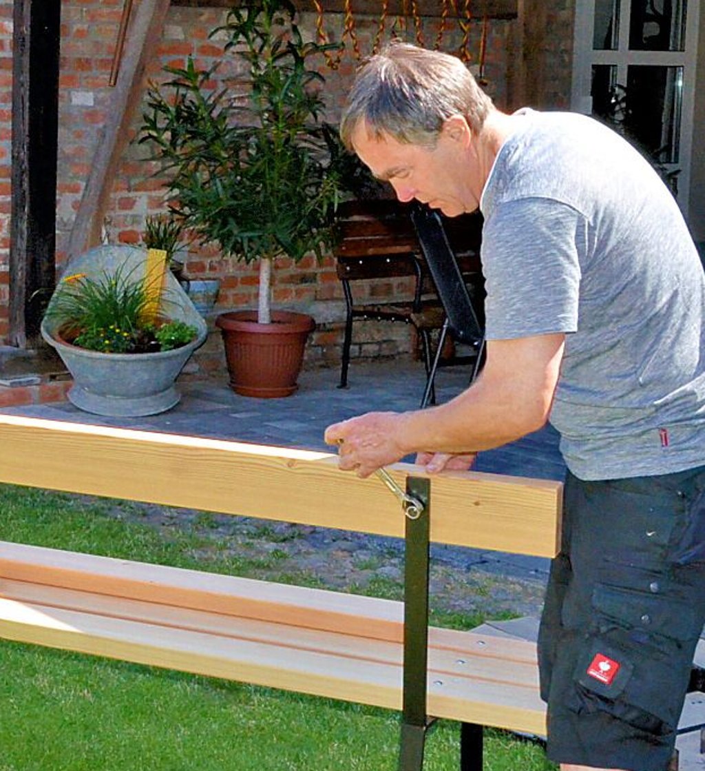 Harald Henningsen schraubt die neuen Sitzbänke zusammen.