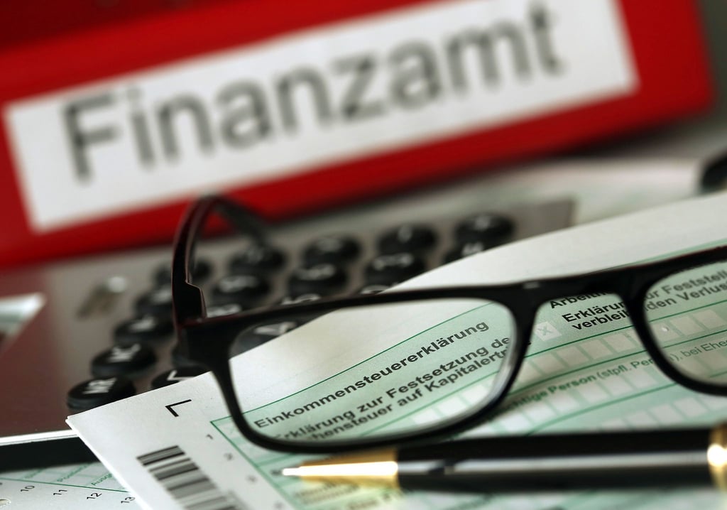 ARCHIV - ILLUSTRATION - Auf einem Vordruck für die Steuererklärung liegt am 20.11.2013 vor dem Aktenordner mit dem Aufdruck „Finanzamt“ ein Stift und eine Brille.