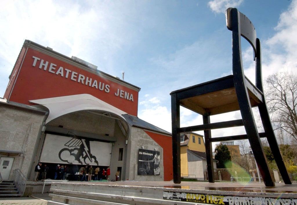Blick auf ein auf den Theatervorplatz in Jena abgestellter Stuhl.