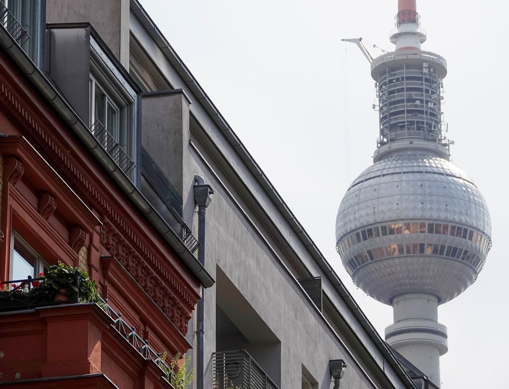 Eine Häuserfassade mit Wohnungen in Berlin-Mitte, hinter den Dächern ist der Berliner Fernsehturm zu sehen.