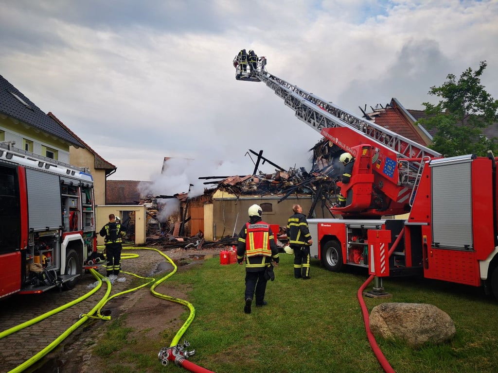 Kameraden der Feuerwehr löschen am Mittwochmorgen von einer Drehleiter den Dachstuhl der Scheune in Büschdorf.