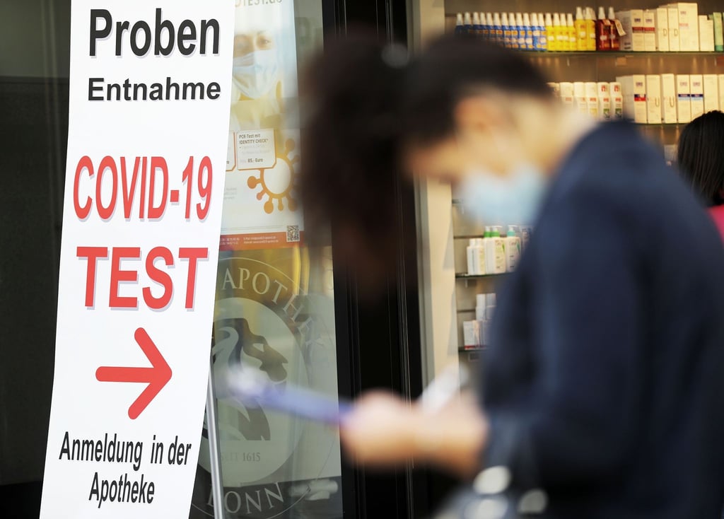 Eine Frau füllt vor einer Apotheke in Bonn ein Formular für einen Covid-19-Test aus.