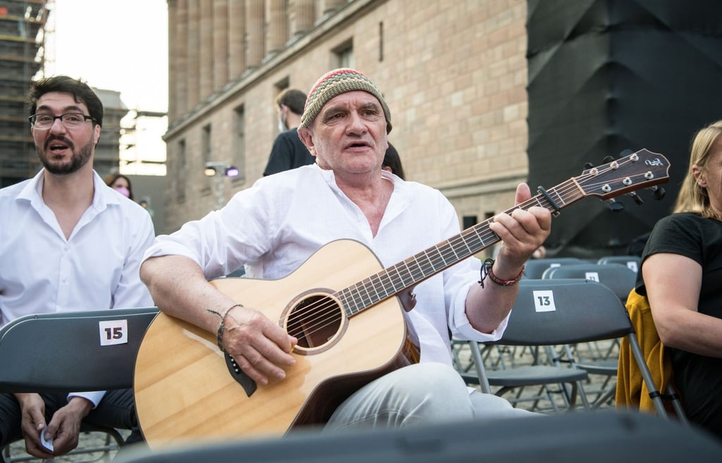 Protagonist Dieter Bachmann (M) spielt Gitarre auf der Museumsinsel vor der Vorführung des Films „Herr Bachmann und seine Klasse“ beim Open Air Cinema im Rahmen der Berlinale.