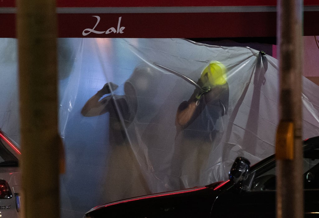 Feuerwehrleute hängen Planen auf.