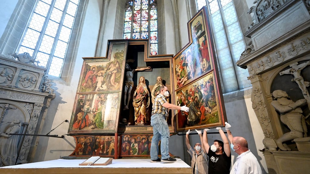 Um ein möglicherweise neu entdecktes Werk von Albrecht Dürer sichtbar zu machen, klappen Kirchenmitarbeiter der Johanneskirche ihren spätgotischen Flügelaltar zu.
