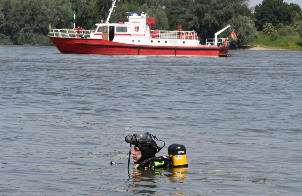 Ein Taucher der Feuerwehr sucht nach den zwei vermissten Mädchen.