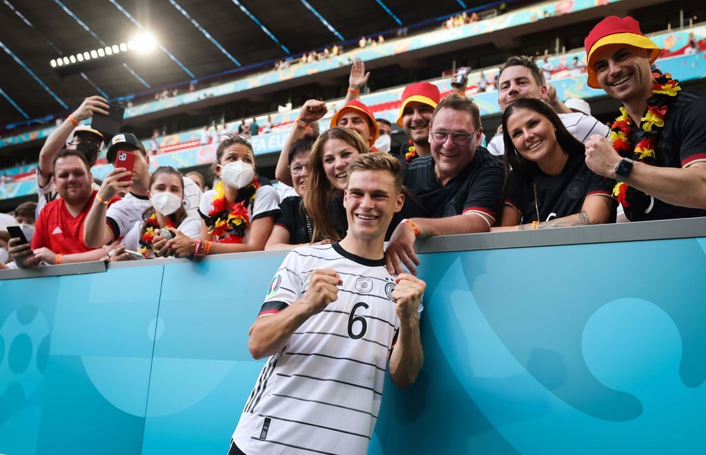 Joshua Kimmich macht nach dem Portugal-Spiel ein Foto mit seiner Freundin, seiner Familie und deutschen Fans.
