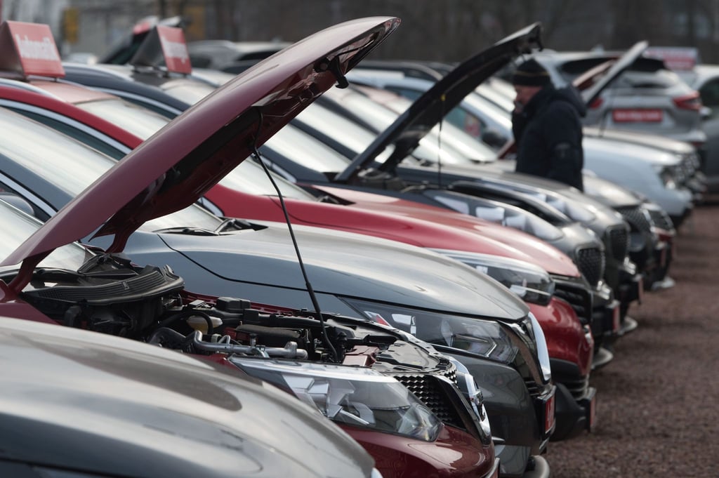 Neu- und Gebrauchtwagen stehen bei einem Autohändler nebeneinander.