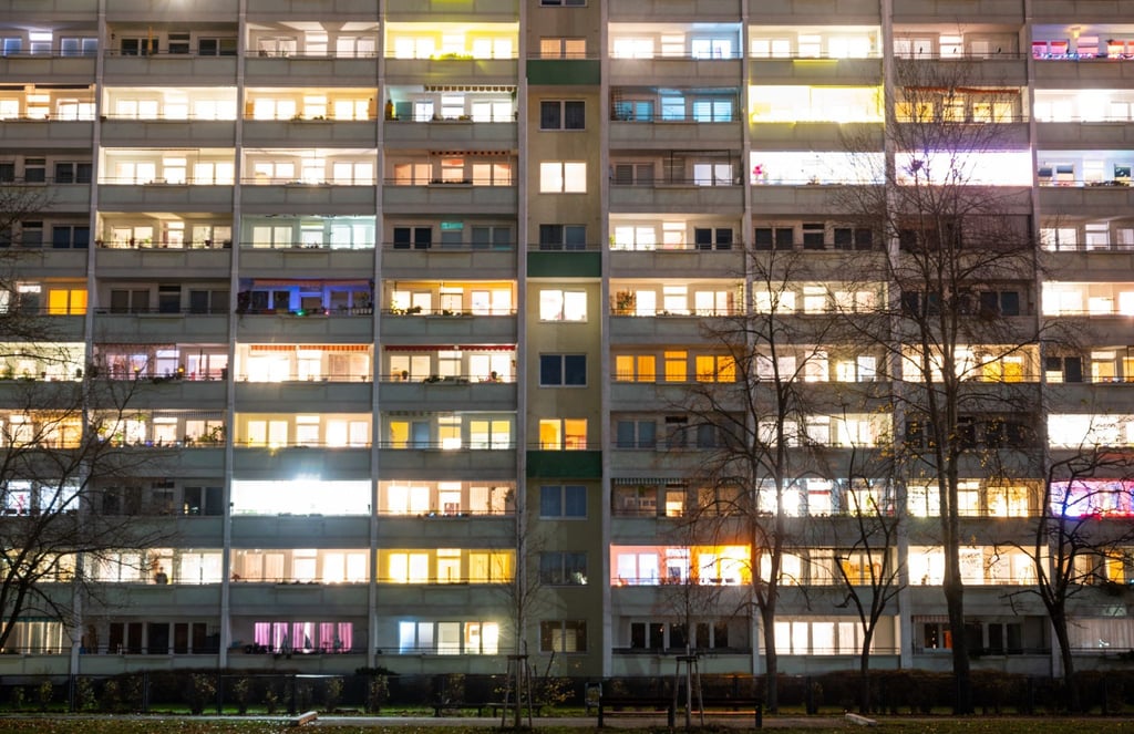 In einem Hochhaus sind einige Fenster beleuchtet.