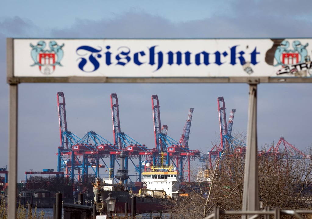Hochgeklappte Containerbrücken sind hinter dem Eingangsschild zum Fischmarkt zu sehen.