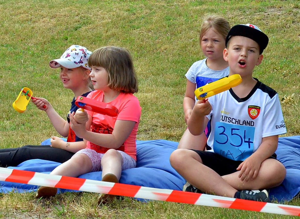 Mit Rasseln feuerten die Kinder, die sich gerade ausruhten, die Läufer beim Rundkurs an.
