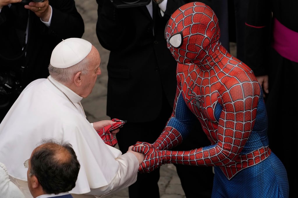 Papst Franziskus (l) spricht am Ende seiner wöchentlichen Generalaudienz mit einem Mann im Spiderman-Kostüm.