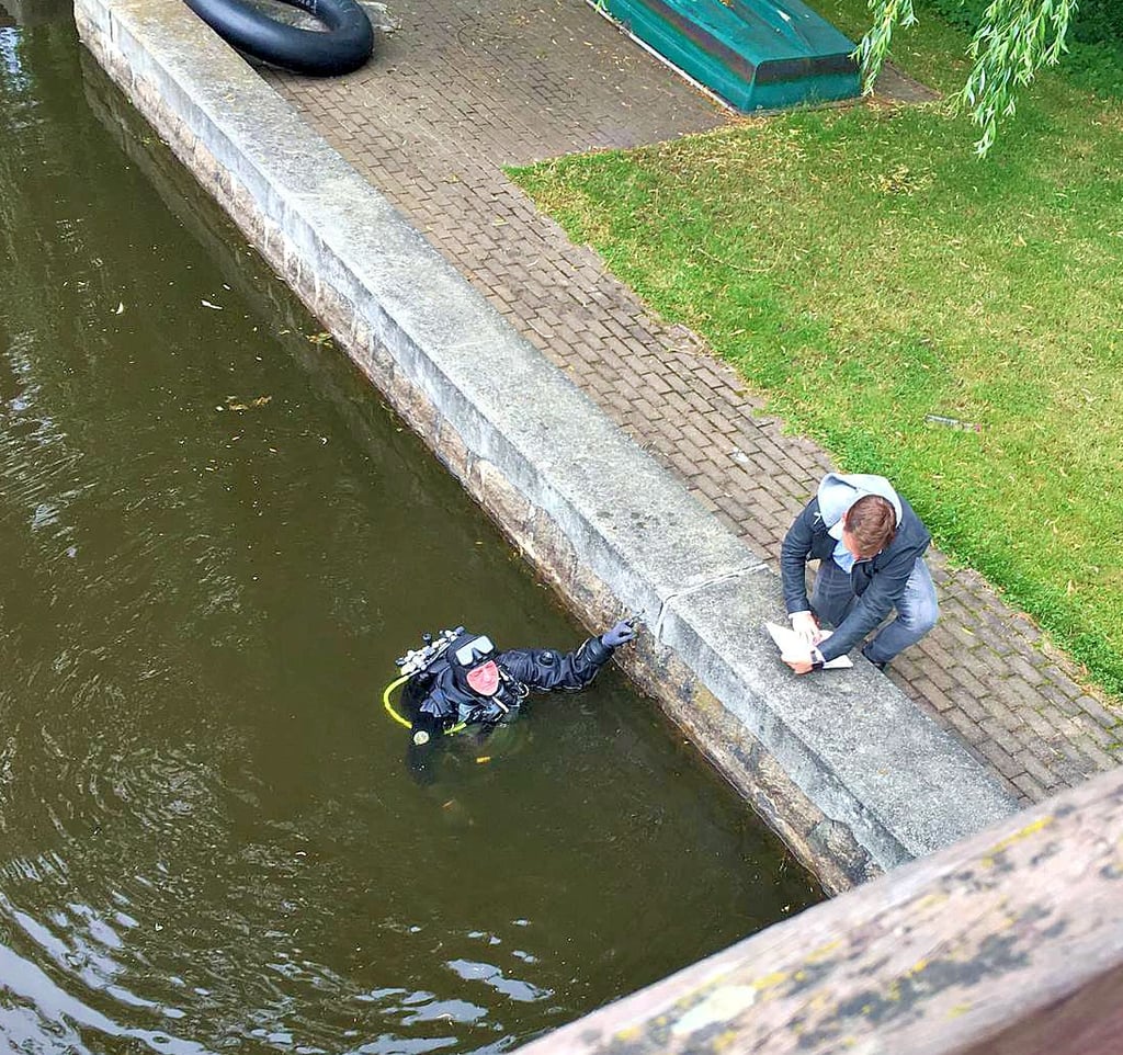 Andreas Weingarten (im Wasser), Leiter des Bauhofs der Stadt Oberharz am Brocken, taucht im Waldseebad Hasselfelde, um einen Defekt im Ablauf zu reparieren.