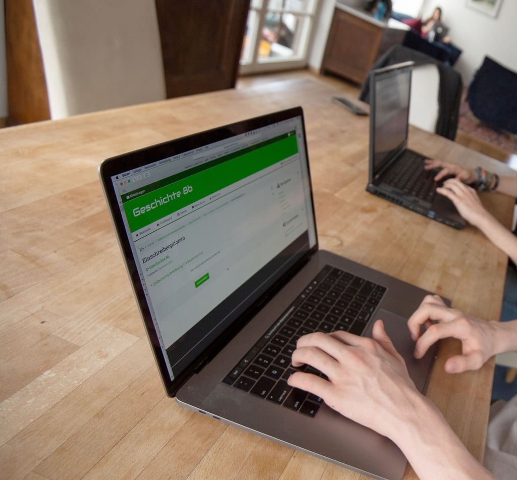 Ein Student bedient an einem Notebook die Lernplattform Moodle.