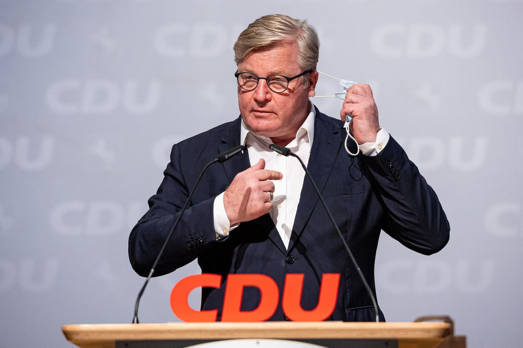 Niedersachsens Verkehrsminister Bernd Althusmann nimmt seine Mund-Nasen-Maske ab.