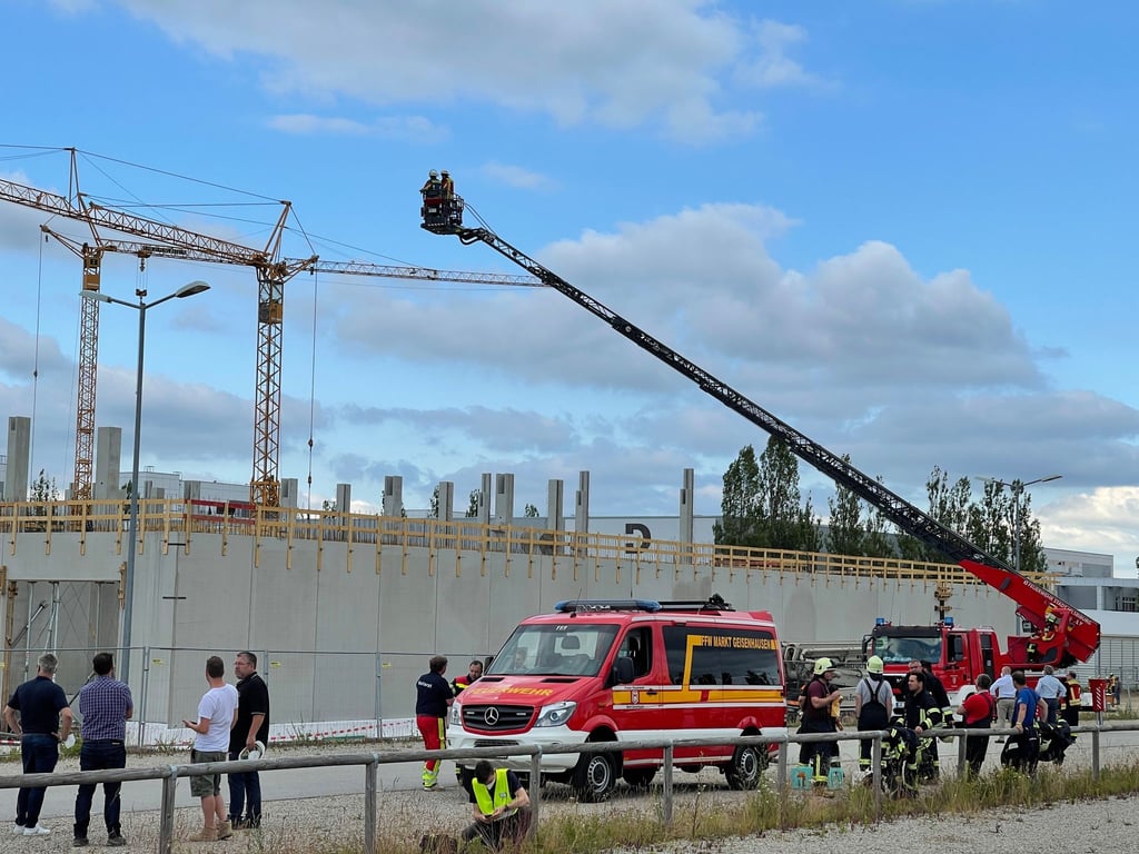 Feuerwehrleute mit einer Drehleiter sind an der Baustelle im Einsatz, wo das Unglück geschah.